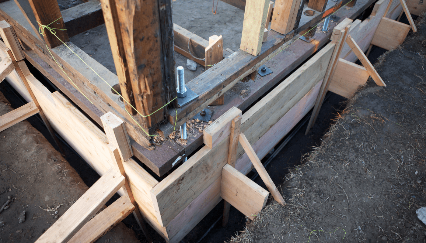 Wood braces hold foundation repair structure in place on a house where a foundation is being restored.